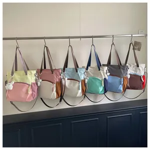 Vue détaillée de grands cabas colorblock avec des sangles élégantes et des pendentifs mignons.