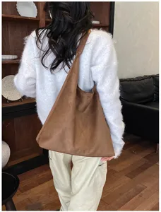 Vista dettagliata della borsa a spalla marrone retrò in camoscio con grande capienza casual.