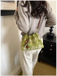 Green vintage embroidered bucket bag, detailed shoulder strap and charm for casual daily wear.