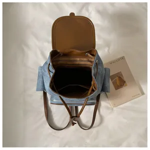 Detailgezicht van blauwe denim rugzak interieur, gestreepte voering, bruin leer.