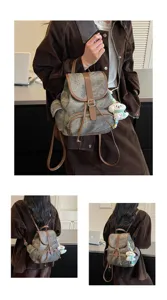 Casual vintage damesrugzak met bruine afwerking en pluche hanger, ideaal voor dagelijks gebruik.