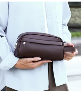 Detailed close-up view of a stylish brown leather men's clutch bag with a handy wrist strap.
