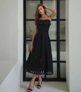 Detailed shot of black strapless cutout one-piece swimsuit with chic ruffle and eyelet design.