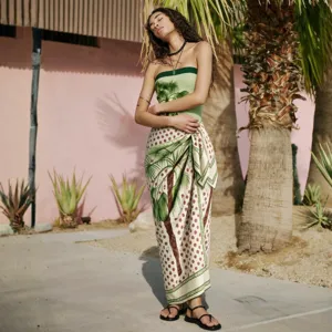 Stylish palm tree print strapless bandeau swimsuit set with matching wrap skirt for beach.