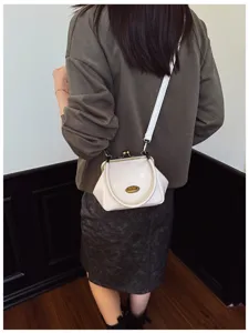 Detail view of retro kiss-lock shoulder bag, premium solid PU leather mini crossbody design.
