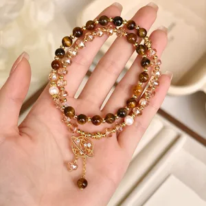 Bracciale a doppio strato in occhio di tigre con ciondolo pianeta elegante e chic.