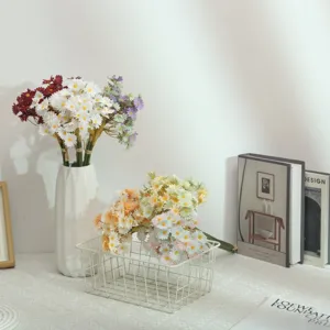 Artificial daisy flower bouquet in ceramic vase and wire basket, fresh home decor detail view.
