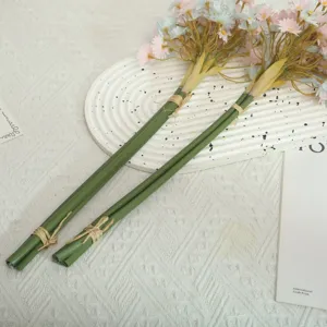 Close-up detail of artificial daisy flower bouquet with green stems for home decor.