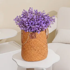 Detailaufnahme künstlicher lila Schleierkrautblüten im geflochtenen Korb für Deko.