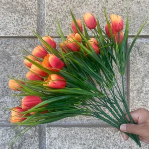 Artificial tulip bouquet detail showing orange flowers and green leaves for decoration.