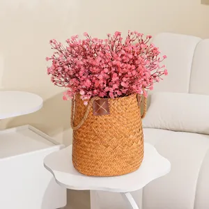 Künstliche rosa Schleierkrautblüten im geflochtenen Korb für Heimdekoration und Tischdisplay.