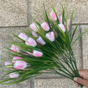 Artificial small tulip bouquet detail shot, vibrant pink flowers with green leaves for decor.
