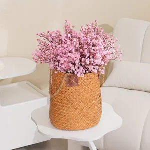 Künstliche rosa Schleierkrautblüten im geflochtenen Korb für elegante Innendekoration Zuhause.