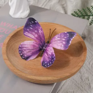 Gros plan sur accessoire papillon 3D violet sur plateau en bois pour details de bricolage