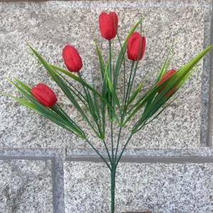 Detail view of artificial red tulips with green leaves and stems, perfect for home decor.