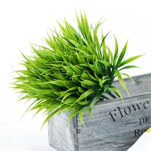 Artificial plastic green grass detail view in vintage wooden planter box prop decoration.