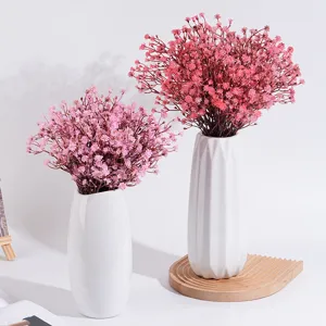 Kunstliche Schleierkraut Blumen in weissen Keramikvasen fur die Tischdeko zu Hause Party.