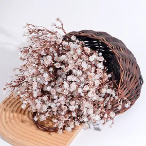 Nahaufnahme künstlicher Herbst-Gypsophila-Blüten aus einem Korb auf Holzbasis dekorativ.