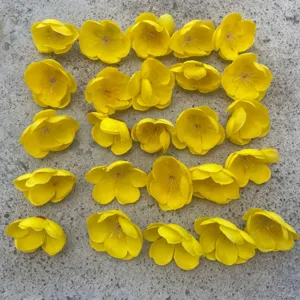 Detail view of yellow artificial plum blossom flowers arranged for DIY craft accessories and wreaths.