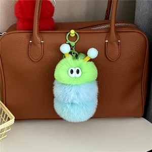 Detailaufnahme eines niedlichen gruen-blauen wuscheligen Raupen-Taschenanhaengers als Schluesselbund.