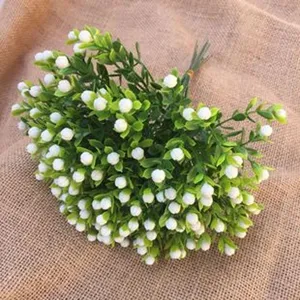Artificial plum blossom branch detail, white flower buds with green leaves, wedding decor.