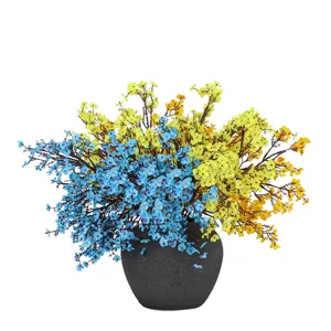 Colorful artificial baby's breath flower detail, blue and yellow bouquet in dark grey pot.