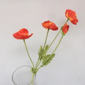 Detail view of vibrant orange artificial poppy flowers in a clear glass vase for decor.