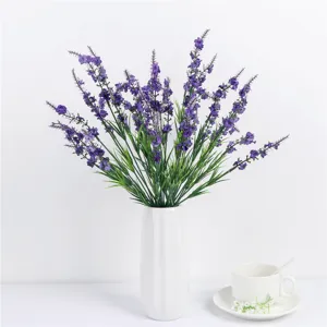 Detailed view of artificial purple lavender flowers in white ceramic vase, rustic home decor.