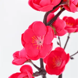 Artificial red plum flower branch for home decor, vibrant floral arrangement piece.