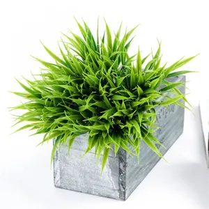 Artificial spring grass potted plant in vintage wooden pot, perfect for home and table decor.