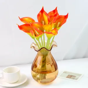 Bouquet de fleurs artificielles calla en PU dans un vase en verre ambré avec tasse.