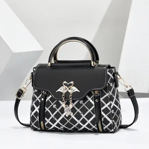Exquisite black shoulder bag featuring chic white diamond patterns and elegant dual swan metal charms.