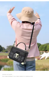 Detail shot of vintage black monogram top handle bag with metal corners and shoulder strap.