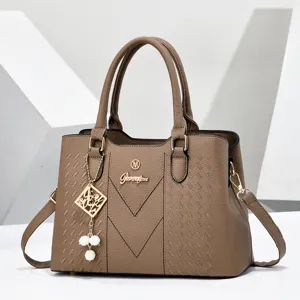 Elegant brown PU leather handbag with chic metal pendant, versatile commuter shoulder bag.