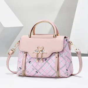 Pink women handbag detail, stylish crossbody shoulder bag with metal handle and grid pattern.