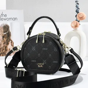 Black PU leather round crossbody bag for women with stylish top handle and adjustable shoulder strap