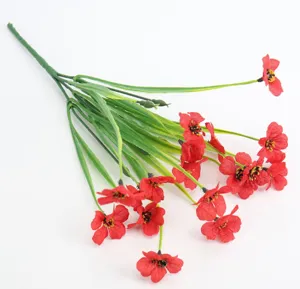 Artificial flower detail shot showing red cloth petals and green plastic stems close-up.