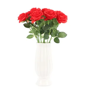 Artificial red roses bouquet in white ceramic vase for home decor, close-up details.
