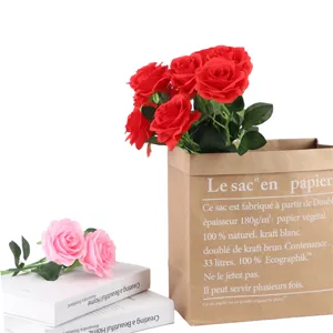 Artificial rose flowers bouquet with brown paper bag and books decor for home wedding.