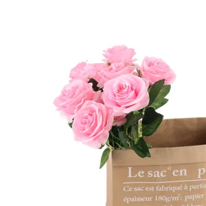 Pink artificial roses bouquet detail in paper bag, ideal for home decor and wedding display.