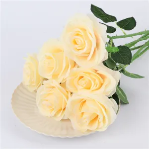 Artificial champagne rose bouquet with green leaves, delicate silk flower details for decor.