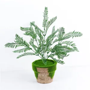 Détail de plante fougère verte artificielle, décor de mousse en pot pour restaurant.