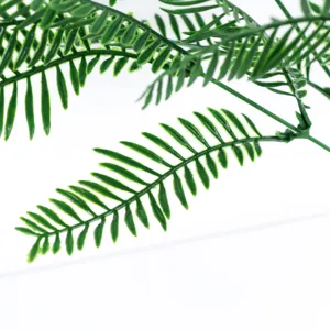 Gros plan détaillé de feuilles de fougère verte artificielle, feuillage en plastique.