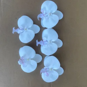 Detailed shot of white artificial orchid flower heads for DIY wedding floral arrangements.