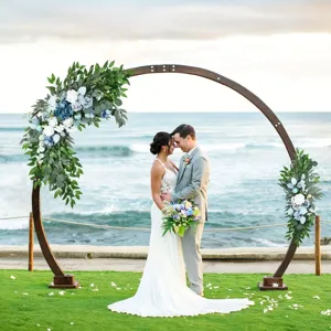 Artificial floral arch decor with blue greenery and wooden round frame for wedding and party.