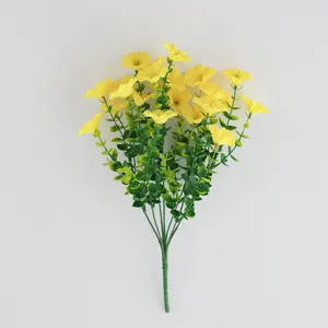 Detail view of artificial yellow morning glory flowers with green leaves for home decor.