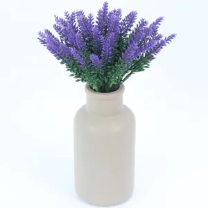 Detailed view of artificial lavender bouquet flowers arranged in a simple ceramic vase.