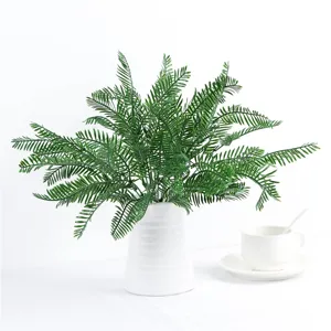 Fausse plante verte fougère artificielle dans un vase blanc pour décoration intérieure.