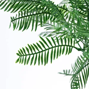Gros plan de feuille de fougère artificielle, plante verte en plastique pour décoration.