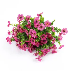 Primo piano dettagliato di fiori di seta viola artificiali con foglie di eucalipto.